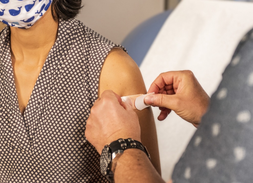 Placing a band-aid on a patient after a vaccination