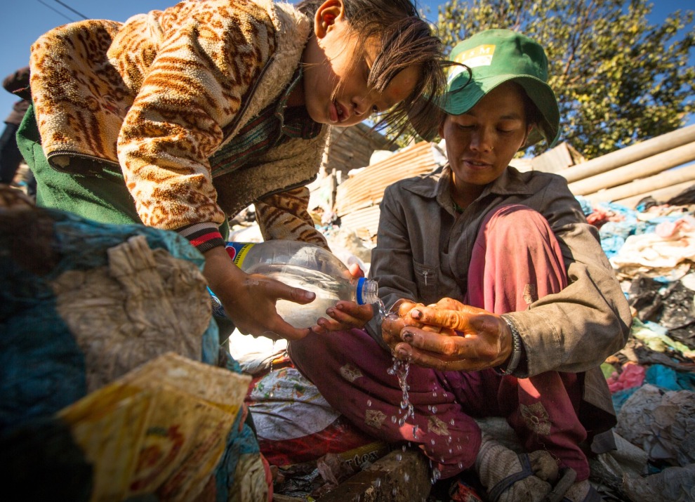 A woman and child in Nepal wash food.