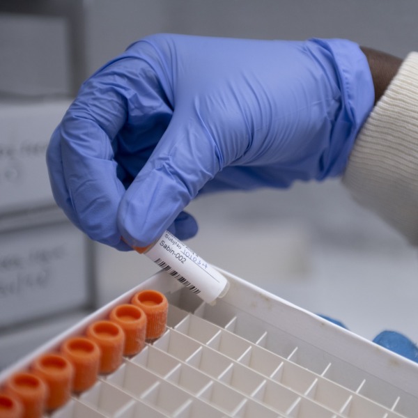 A scientist holding a Sabin vaccine vial.