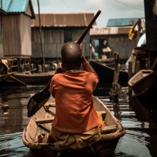 Child rowing a boat in Nigeria.
