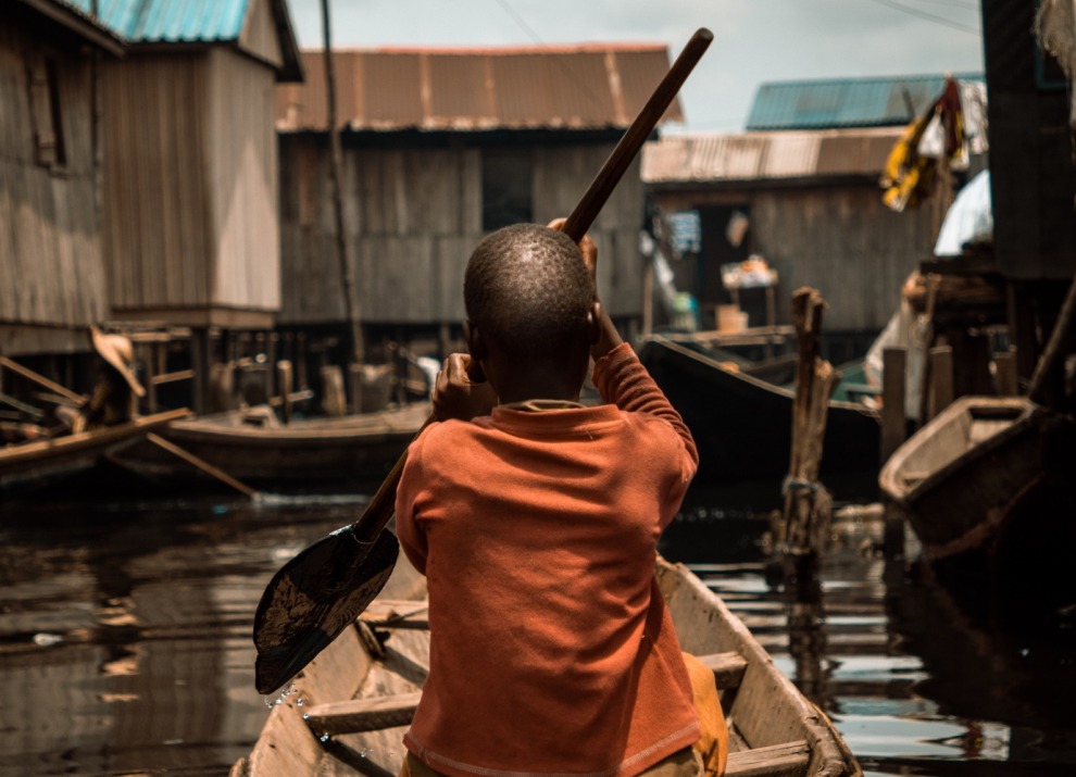 Child rowing a boat in Nigeria.