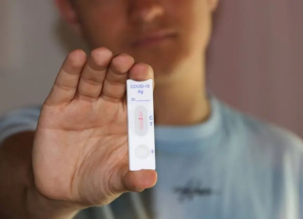 Man holding a COVID-19 test.