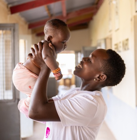 Woman holding her baby in the air