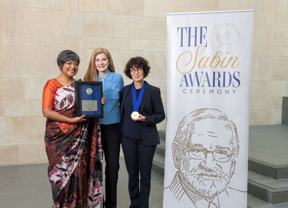 3 people standing by a banner that reads Sabin Awards Ceremony